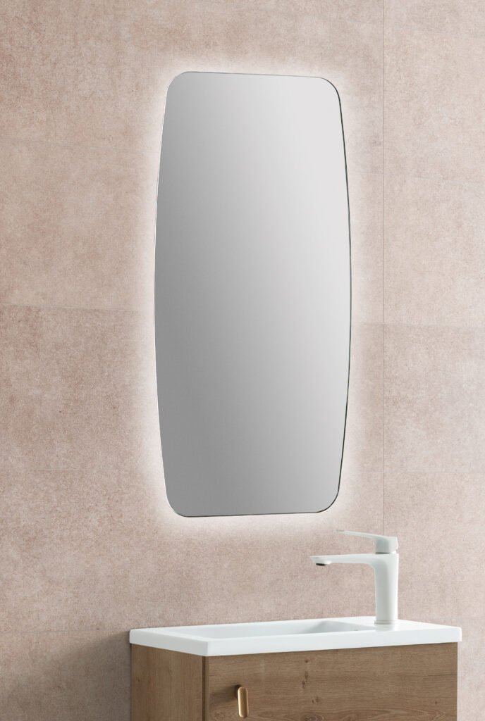 Espejo de baño Bass con iluminación y contorno curvo; fotografía de ambiente, mueble, lavabo, grifería y decoración no incluidos.