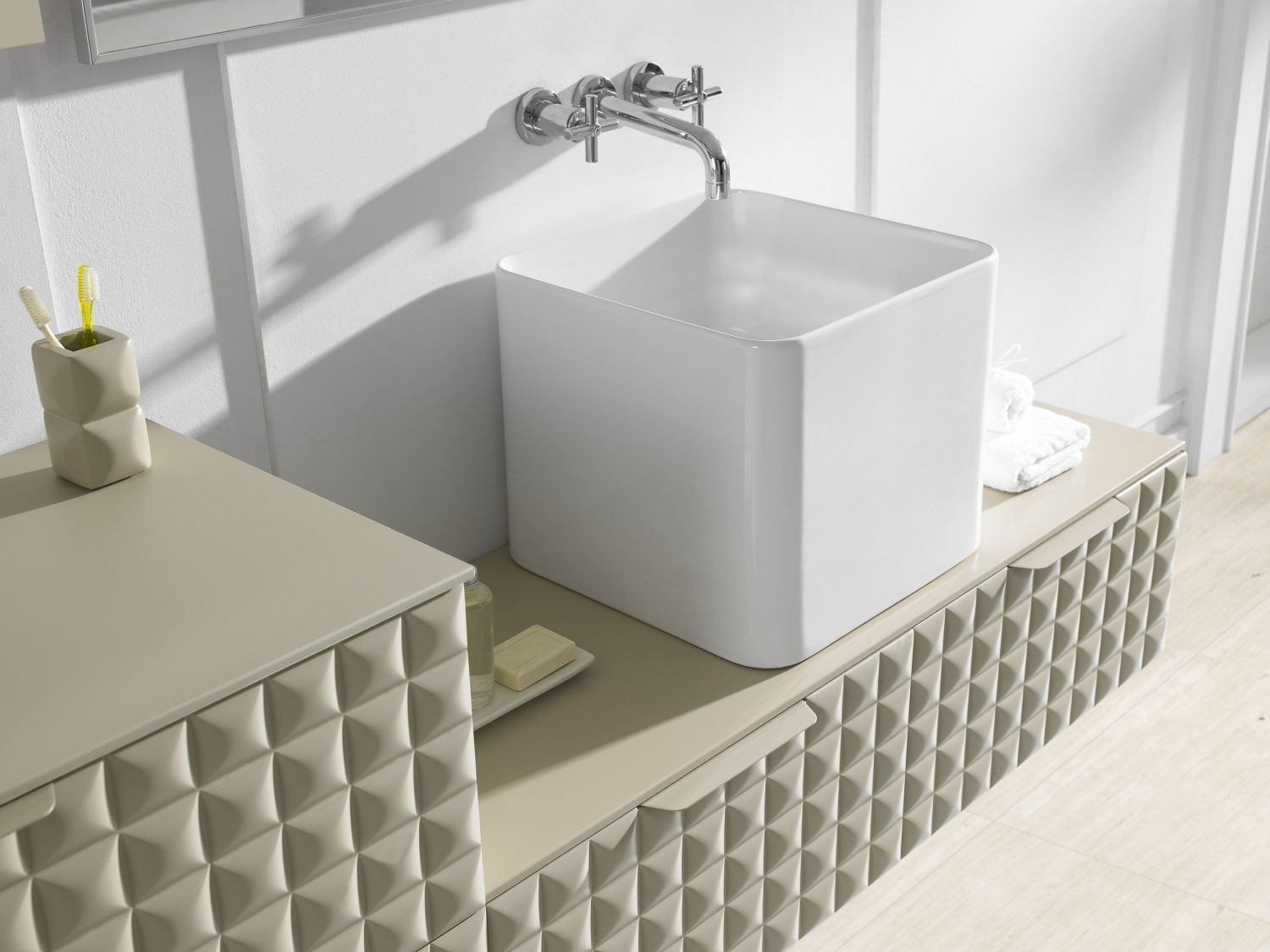 Detalle lateral del lavabo Cube y la unión de los módulos Zeta en arena mate; grifería no incluida