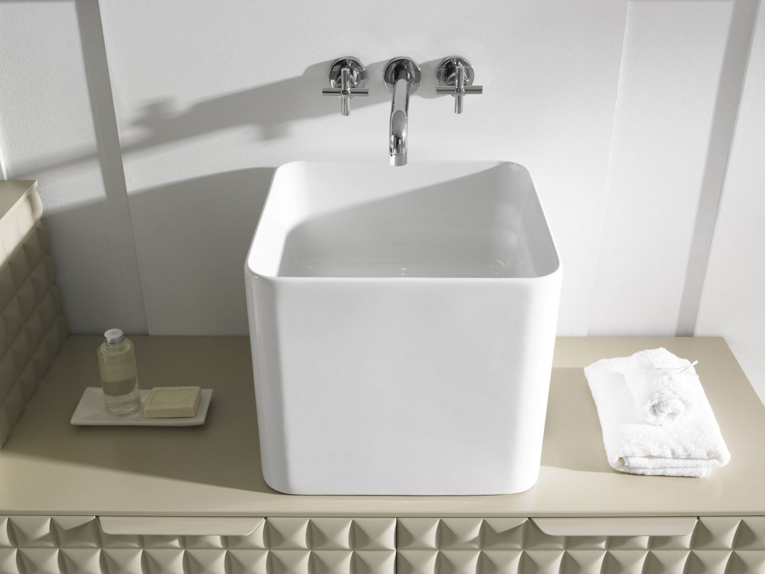 Vista superior del lavabo Cube de porcelana blanca sobre el conjunto Zeta; grifería de la escena no incluida