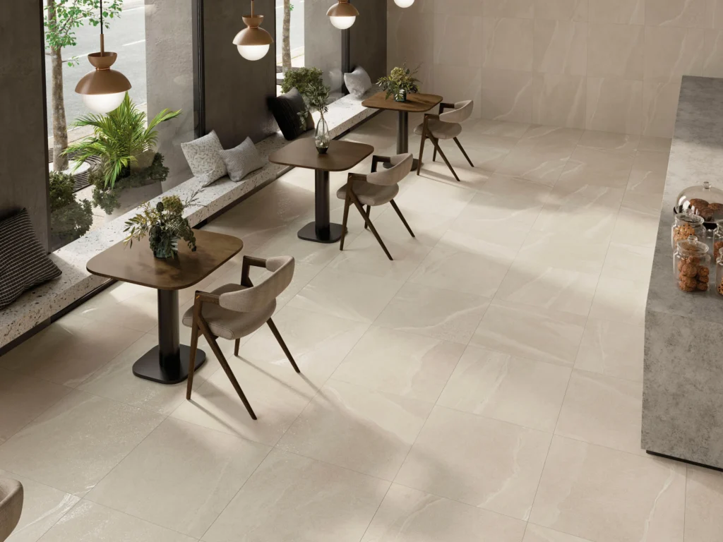 Suelo porcelánico Austral Ivory 120 × 120 cm · ambiente de cafetería